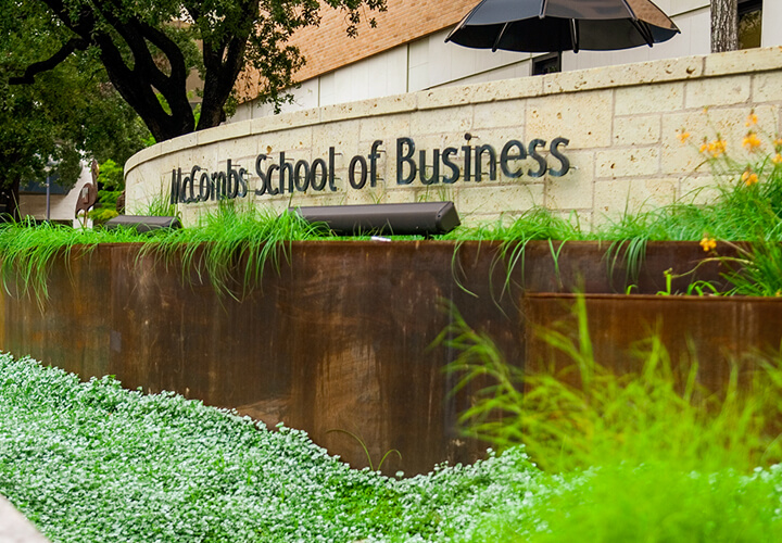 Green plants in front of McCombs School of Business sign