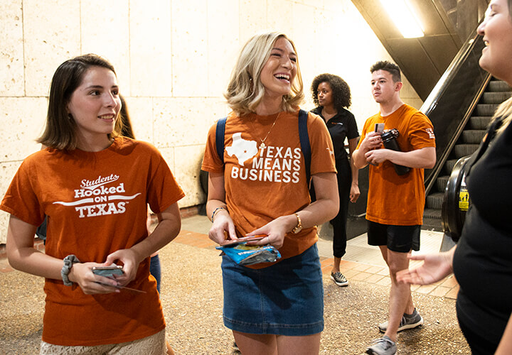 Two students give hook em horns at Gone to Texas event