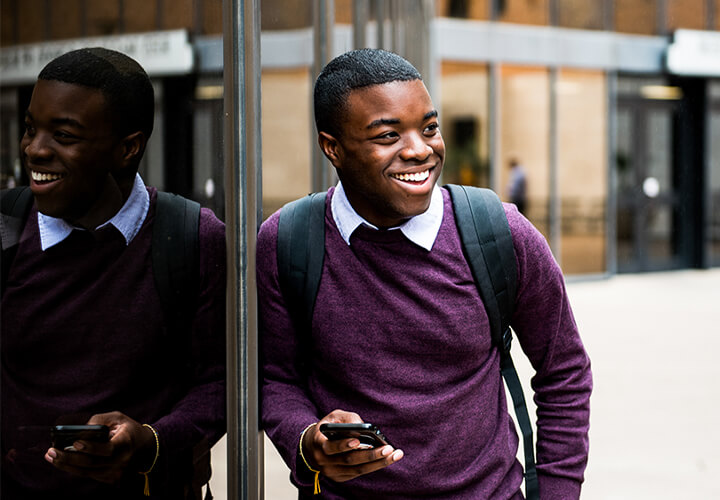 Smiling student stands outside GSB building