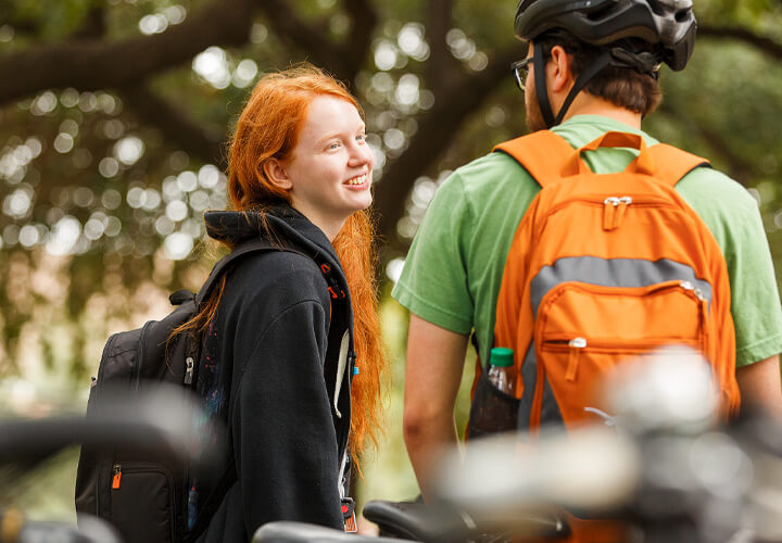 Two talking students wearing backpacks