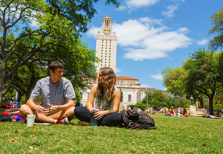 Two students on University of Texas lawn with tower in the background