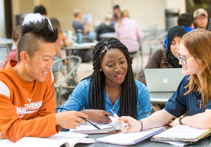 Three students look at notes together