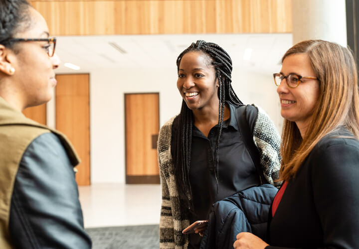 Three students talking in Rowling lobby