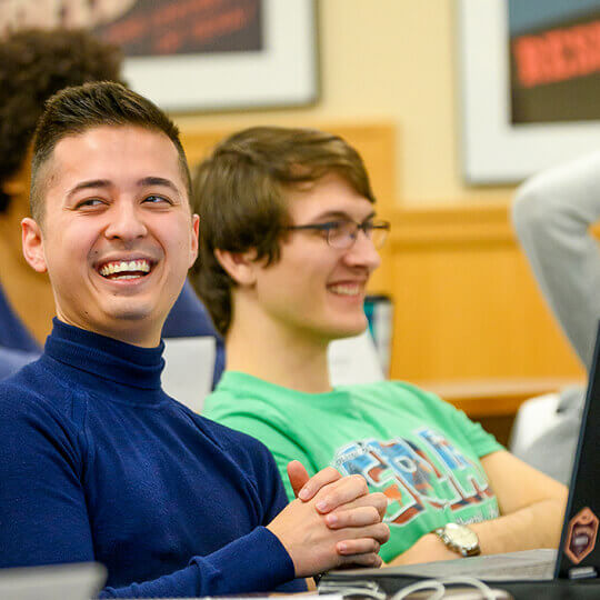 Two MS Program students laugh in class