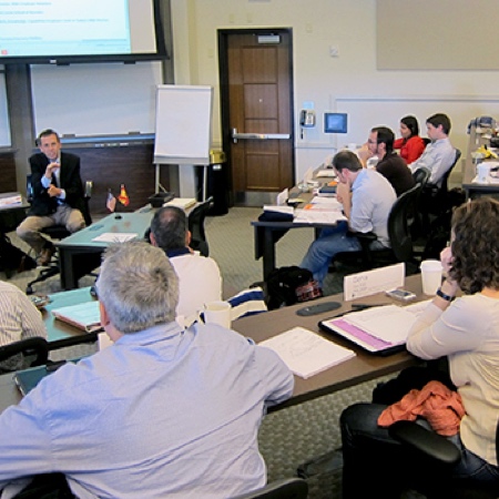 View from the top of tiered seating within a university classroom full of students.